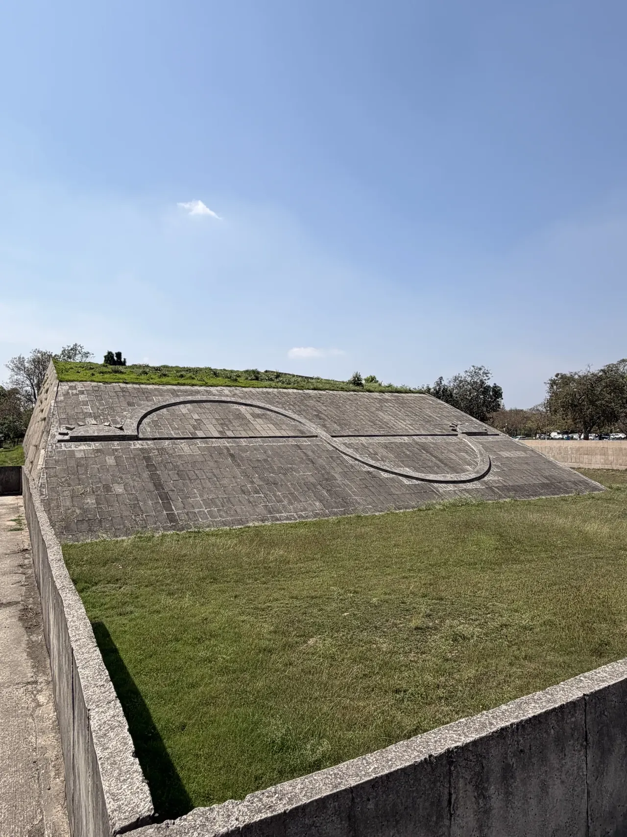 Geometric Hill's spiral concrete pattern under blue sky, Chandigarh Le Corbusier architecture tour