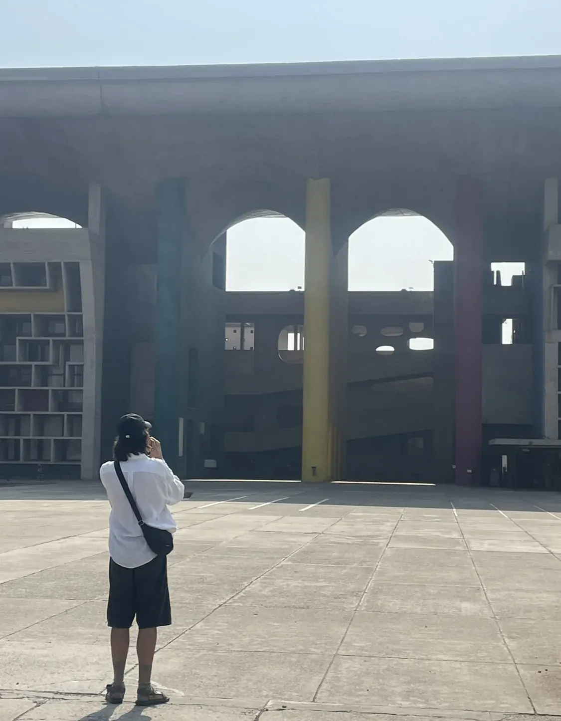 Visitor photographing the colorful pillars of the Palace of Justice entrance, Chandigarh architecture tour
