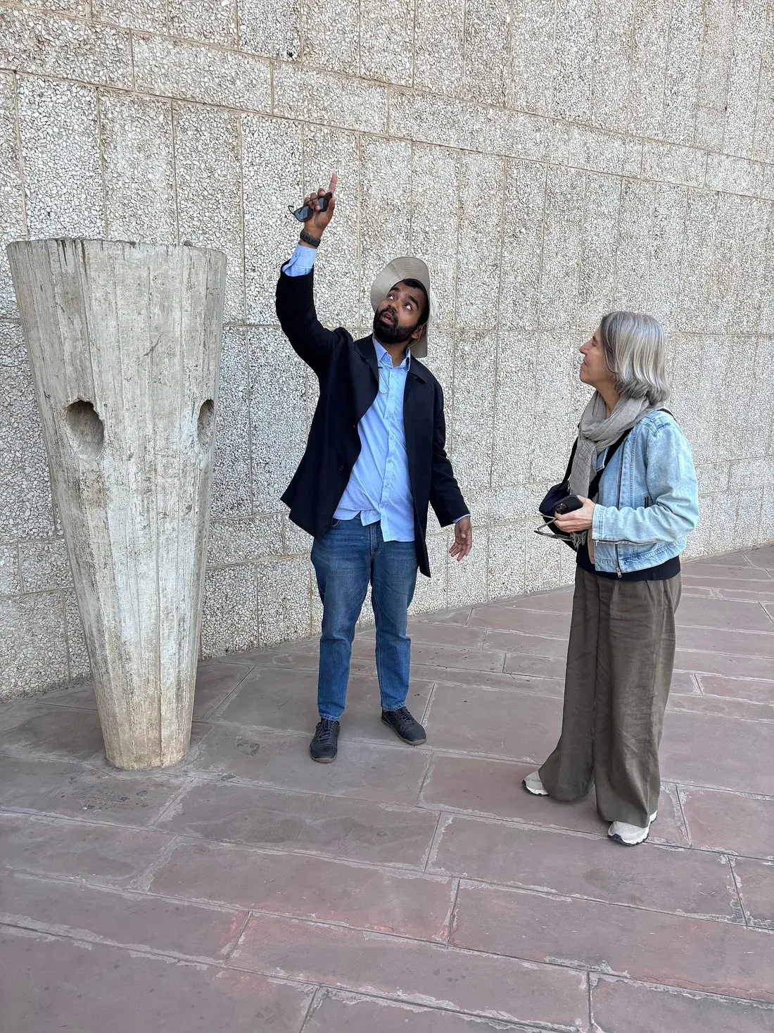 Tour guide Rusty pointing out a sculptural concrete design detail to a guest, Chandigarh architecture and design tour