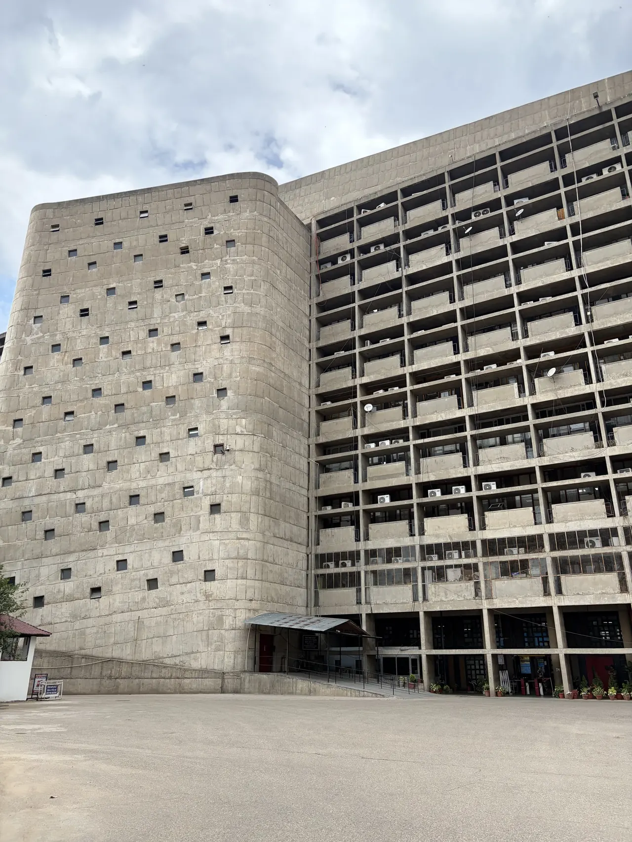 Wide view of the Secretariat facade with its rounded tower and grid of window bays, Le Corbusier Chandigarh architecture tour