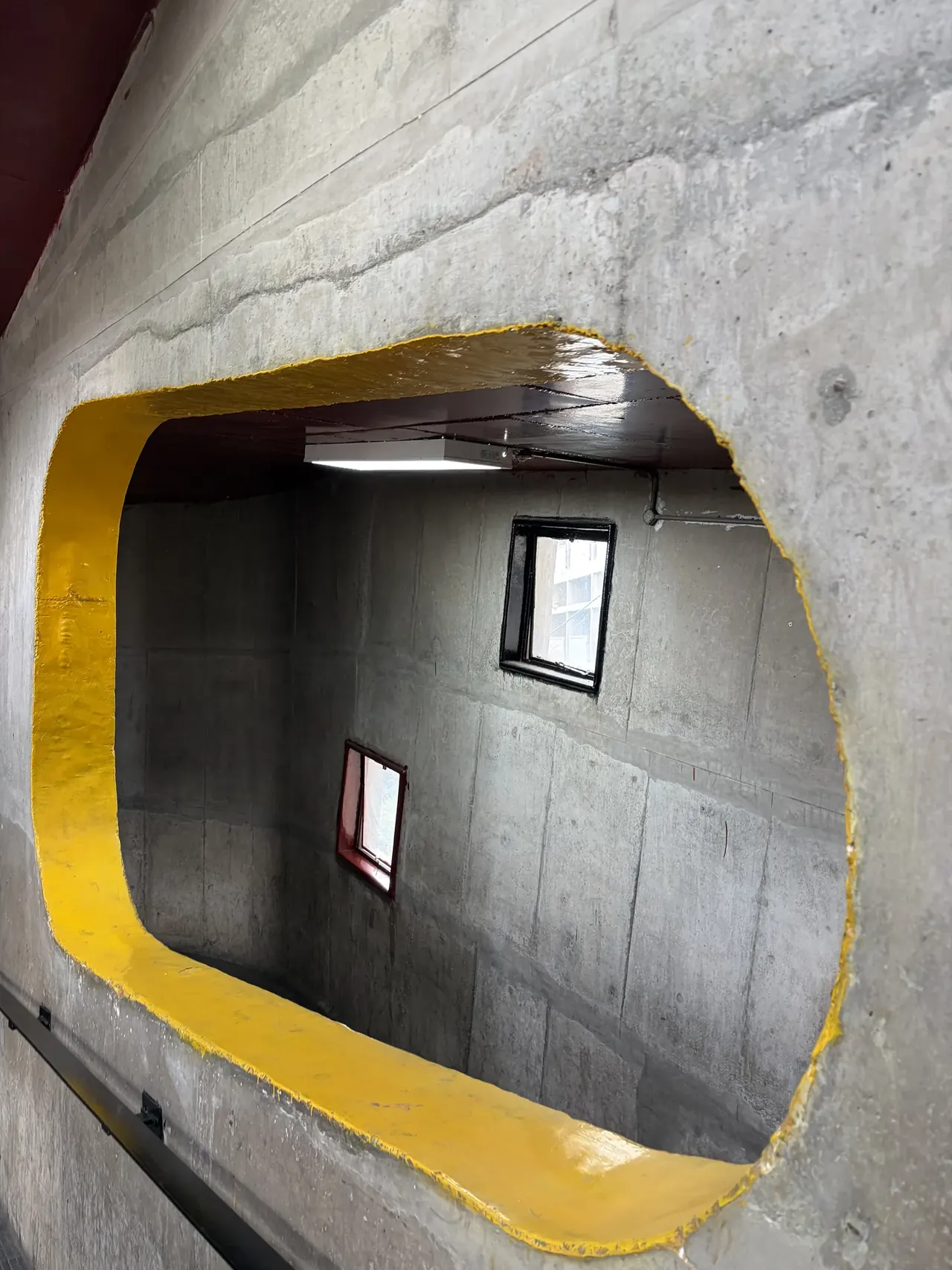 Yellow-bordered concrete window opening looking into the Secretariat corridor, Chandigarh architecture tour